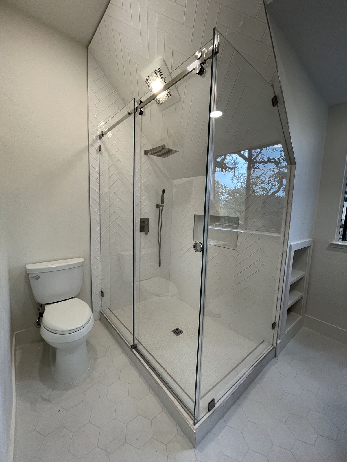Glass-enclosed shower with hexagon tile floor