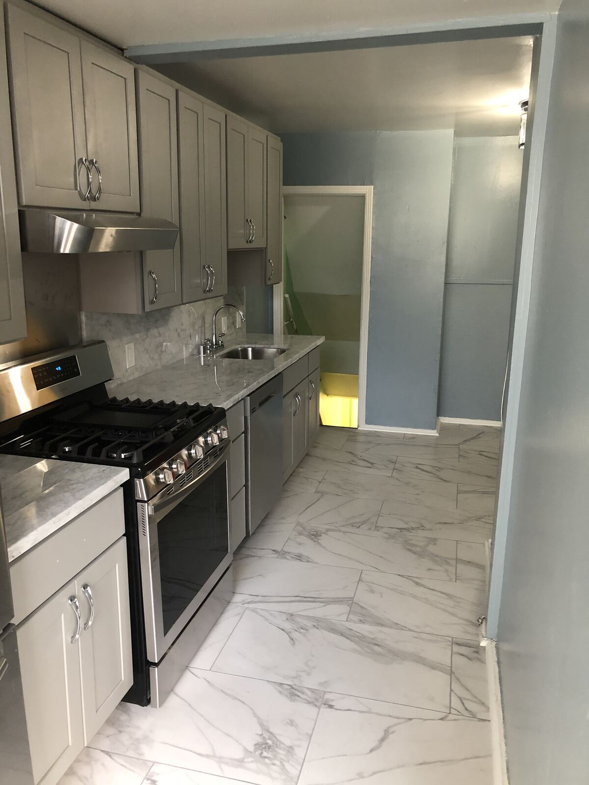 High-end kitchen remodel with marble walls and stainless range